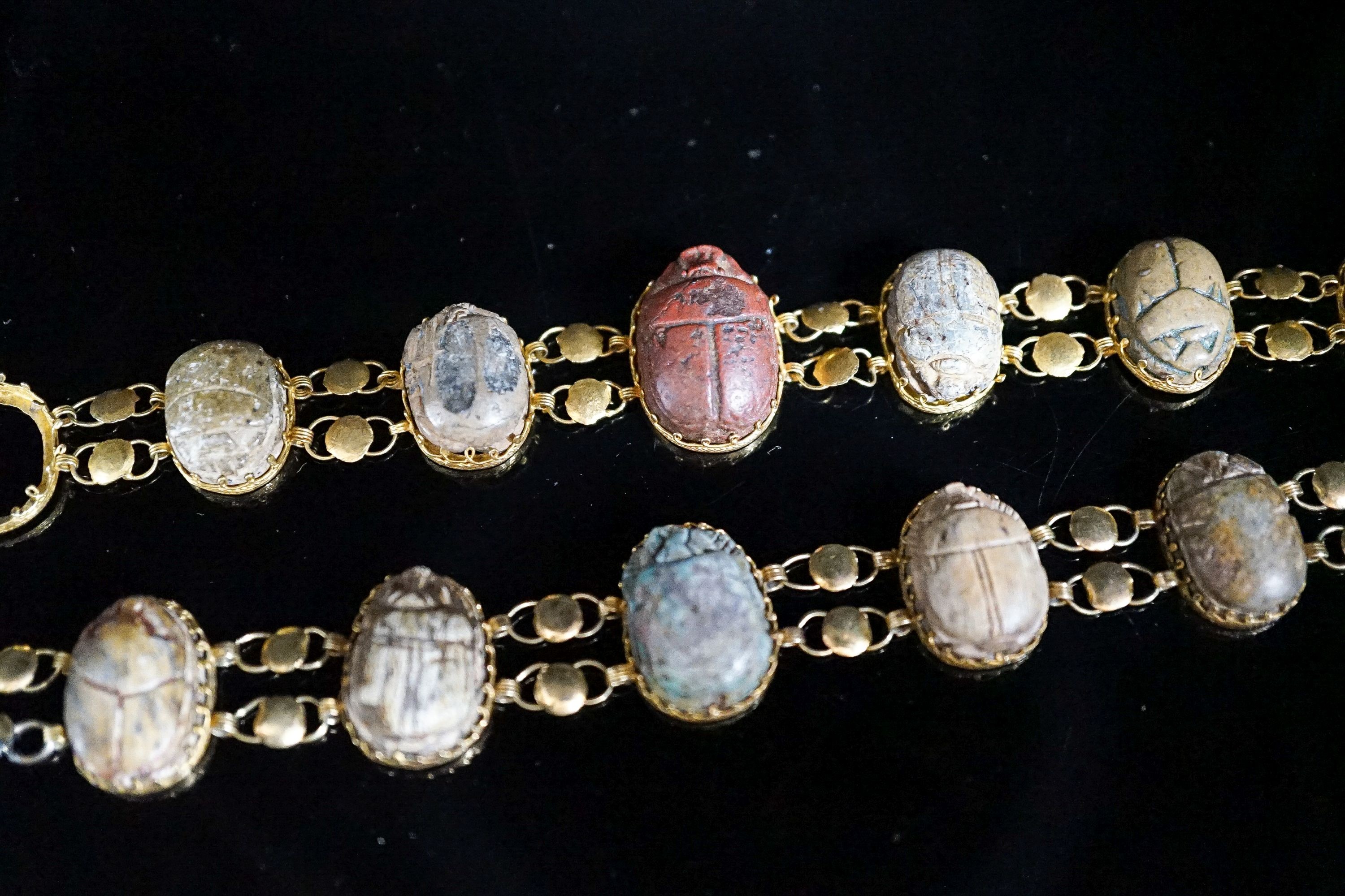 Two similar early 20th century yellow metal mounted scarab bracelets (a.f.), 18.5cm et infra, gross weight 38.1 grams.